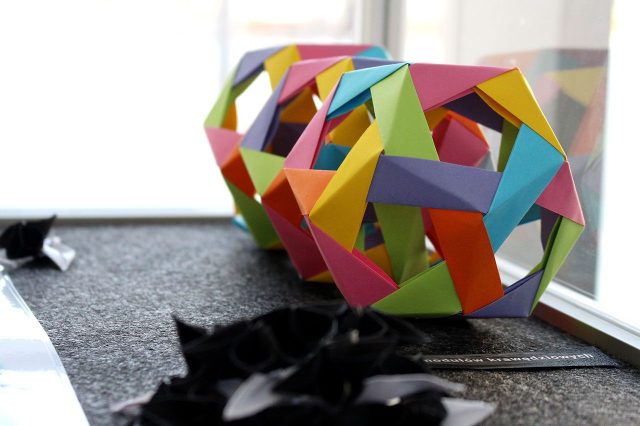 Kolorowy model origami w gablocie wystawowej
