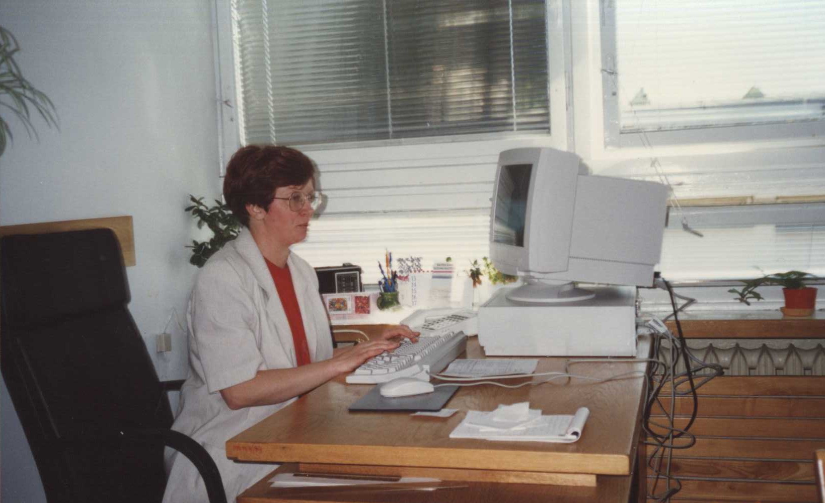 Pomieszczenie biurowe. Siedząca przy biurku i pracująca przy komputerze kobieta w okularach, dyrektor Biblioteki Politechniki Białostockiej mgr Barbara Kubiak.