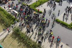 Widok z góry na dużą grupę osób z rowerami.