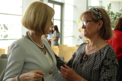 Zbliżenie na dwie rozmawiające ze sobą kobiety, z lewej strony dyrektor biblioteki Maria Czyżewska, z prawej uśmiechnięta kobieta w okularach.