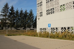 Miejsca parkingowe wyznaczone dla osób z niepełnosprawnościami. W tle budynek Biblioteki Politechniki Białostockie od ulicy Świerkowej w Białymstoku.