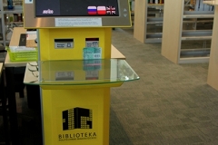Urządzenie do samodzielnego wypożyczenia książek w kolorze żółtym.