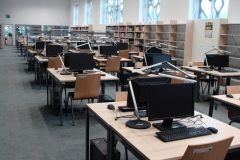 Stoliki z komputerami do pracy dla czytelników Czytelni Elektronicznej. W tle regały na czasopisma.
