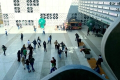 Widok z góry na plac przed budynkiem, na którym tańczy liczna grupa osób.