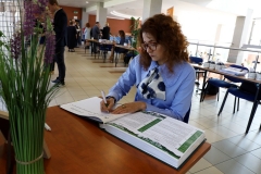 Przy stoliku siedzi Rektor Politechniki Białostockiej  Marta Kosior-Kazberuk i składa wpis do kroniki.
