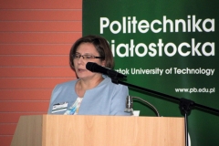 Zastępca dyrektora Biblioteki PB Anna Gogiel-Kuźmicka przemawia z mównicy, ubrana w jasnoniebieski żakiet. W tle baner z napisem: Politechnika Białostocka.