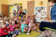 a dywanie przedszkolaki z Przedszkola Samorządowego nr 64 i Pani, czytająca im  książkę.