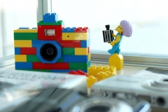 Aparat z kolorowych klocków lego. Obok stoi mini figurka lego.