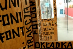 Zbliżenie na szafy zaprojektowane przez prof. PB dr hab. Andrzeja Dworakowskiego z charakterystycznymi czarnymi napisami.