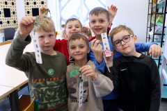 Dzieci pokazują własnoręcznie przygotowane materiały podczas aktywności edukacyjno-plastycznej w sali