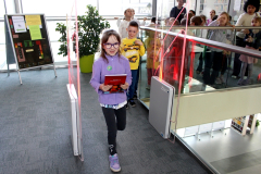 Uczestnicy wydarzenia przechodzą przez bramkę kontrolną w przestrzeni bibliotecznej